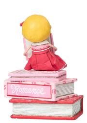 Hand-painted “Love Story” figurine by Lori Mitchell—sweet girl in pink and red dress perched atop a stack of romance books, lost in a love story